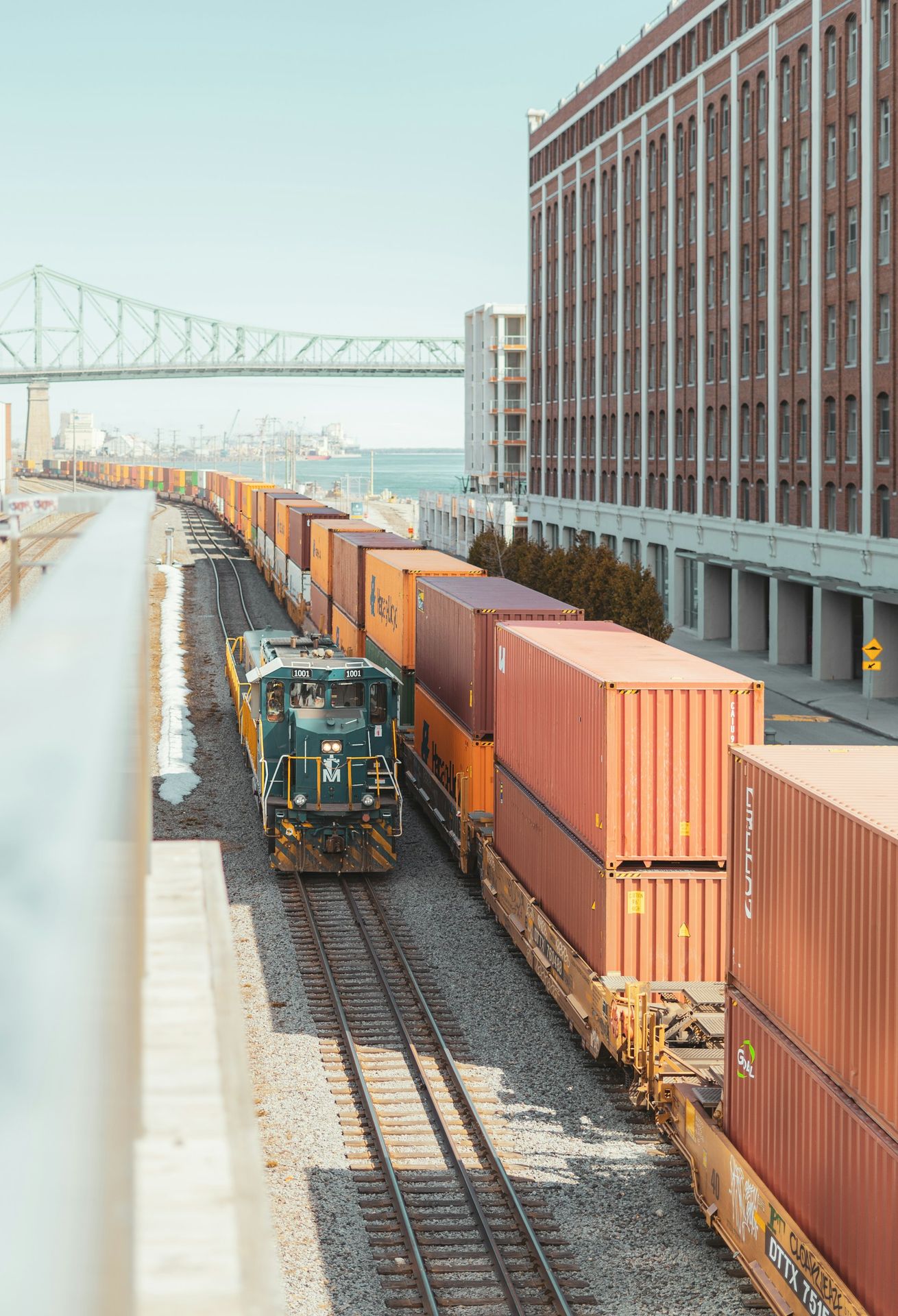 a train traveling down train tracks next to a tall building